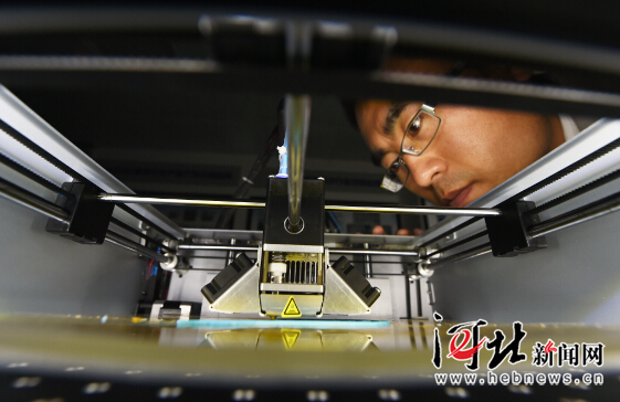在秦皇岛天秦三维数字化技术有限公司，技术人员正在观察3D小型桌面打印机的运行情况。