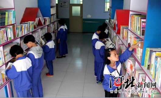 河北省任县留守儿童学校的孩子们在图书长廊阅读书籍。