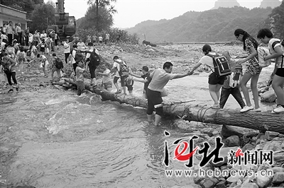 民警护送师生过浮桥。