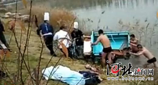 众人正在打捞三轮车(视频截图)。 众人正在打捞三轮车(视频截图)。